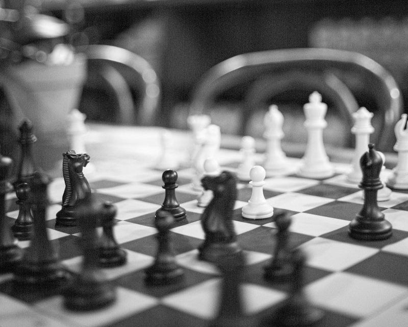 Close-up of a black and white chess set in play.