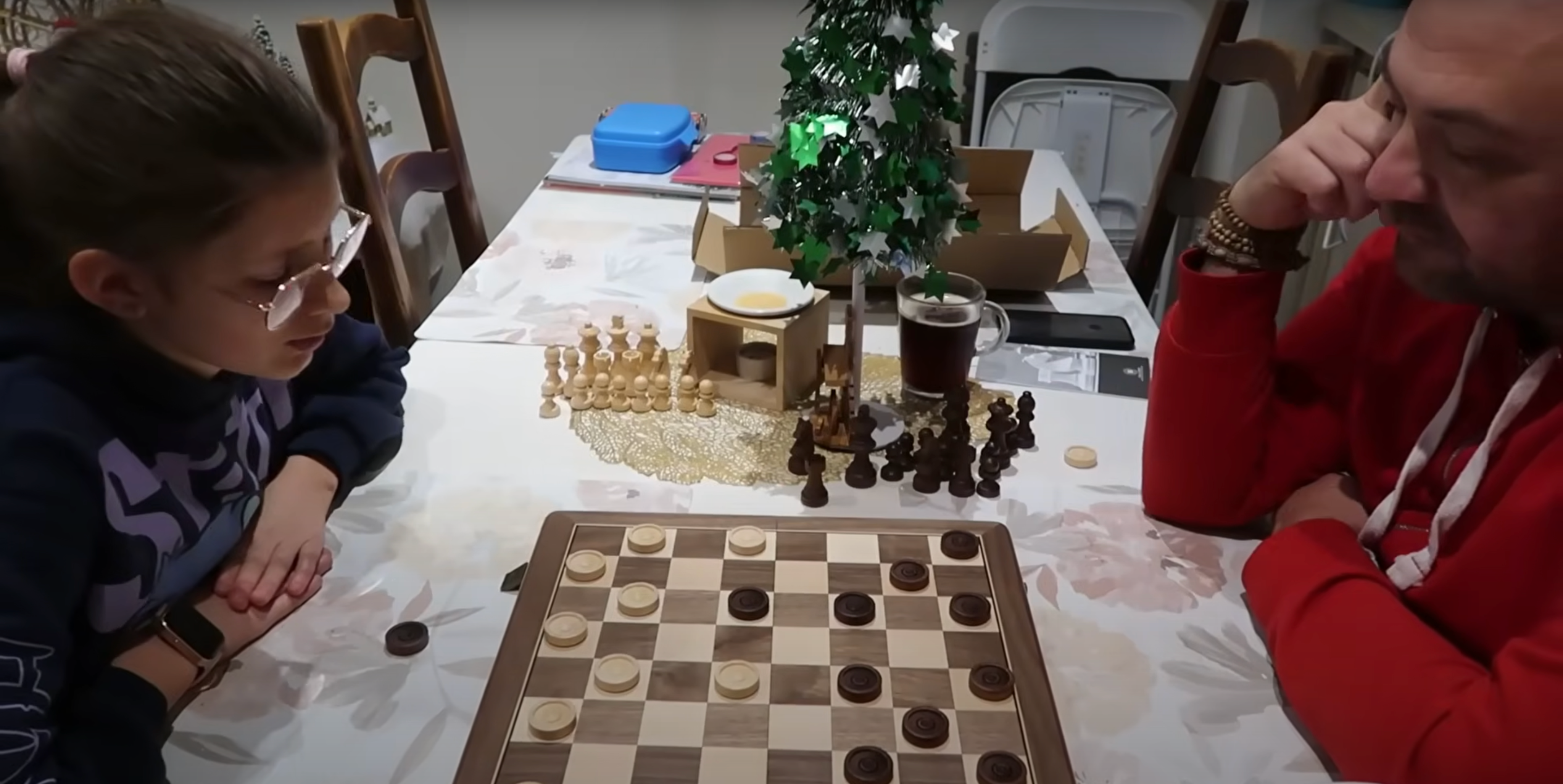 A father and daughter are playing chess.
