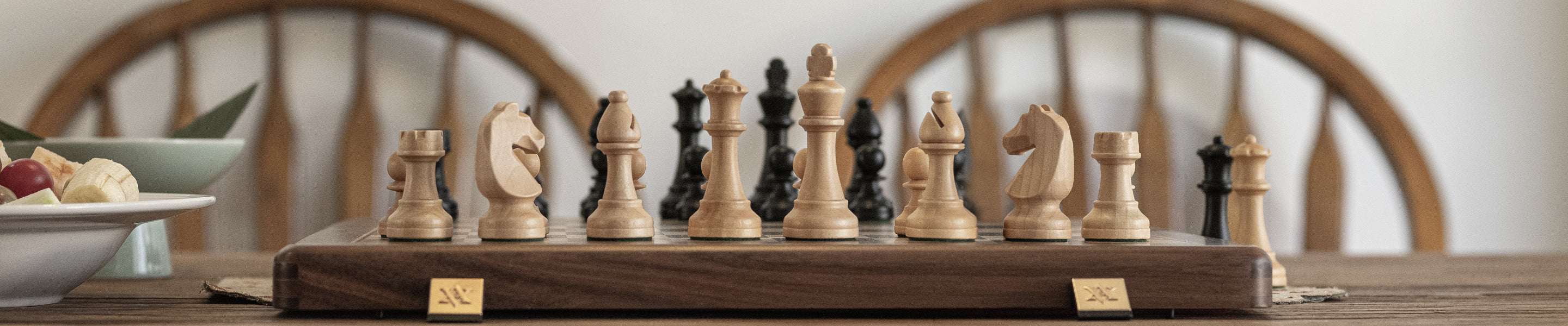 A relaxing afternoon, with an A\&A chess set beside a platter of fresh fruit.